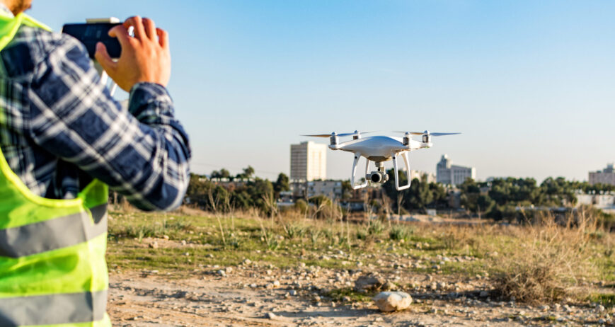 A construction worker operating a drone on a construction site